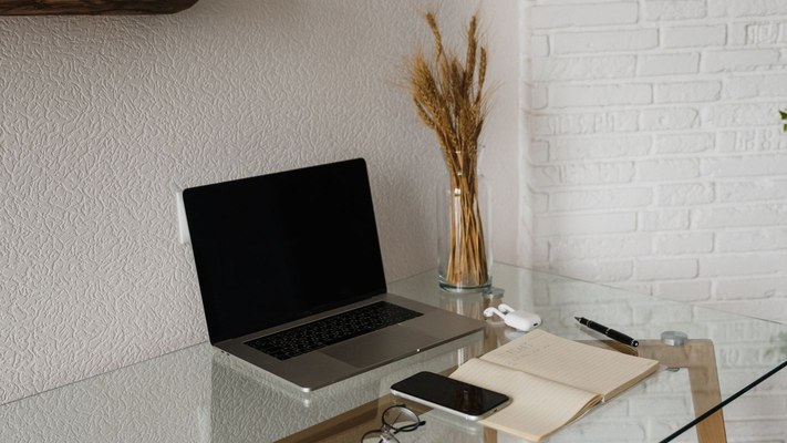 Laptop, smartphone, and notebook on a desk